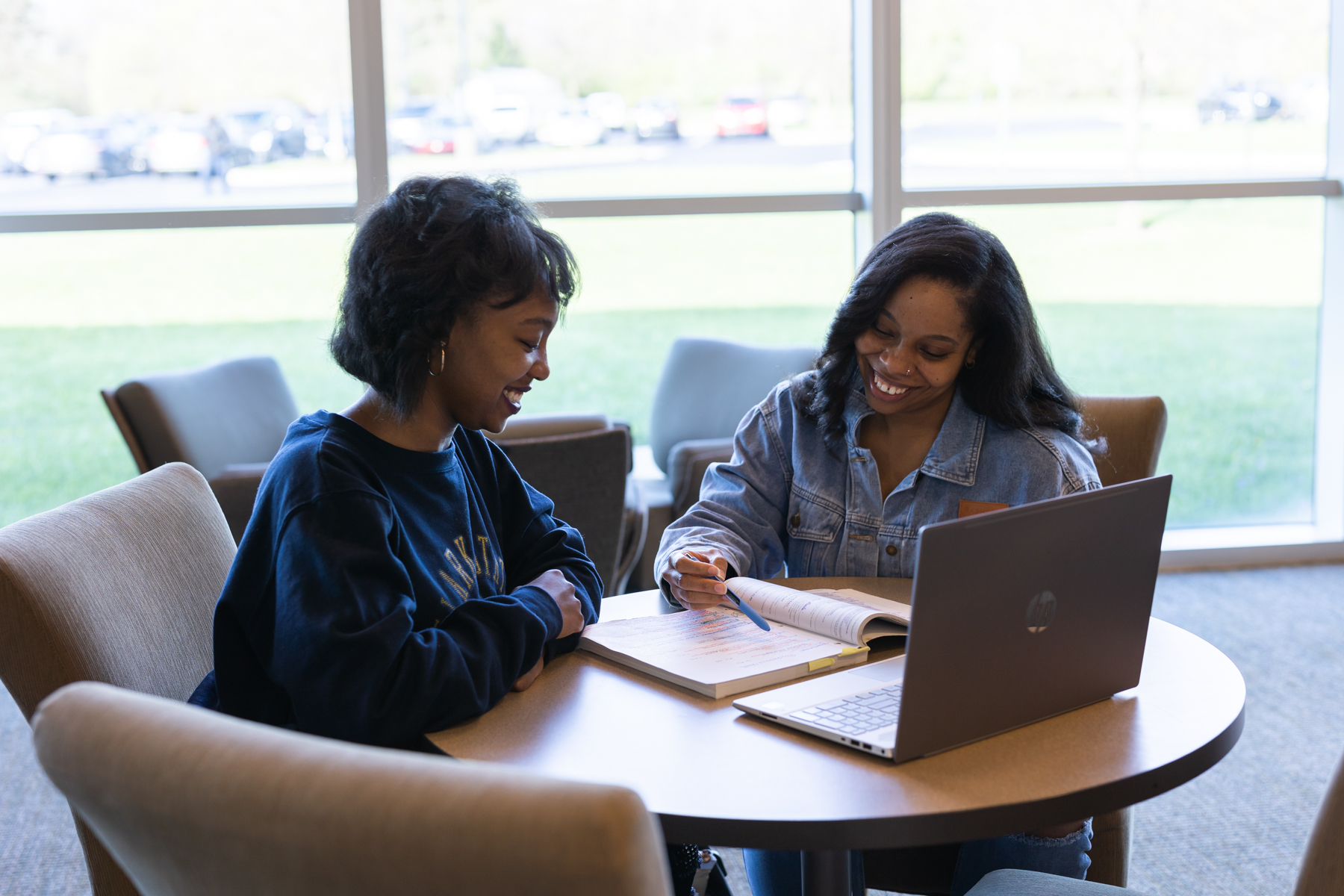 Two female students studying in library.